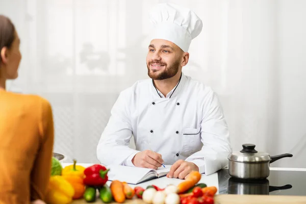 Professionale chef uomo su lavoro intervista parlando con donna in cucina — Foto Stock