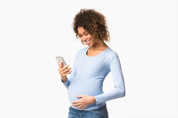 妊娠中のネットワーク電話を使用して期待される女性,白い背景 — ストック写真