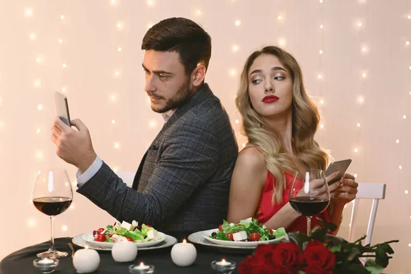 Kíváncsi nő kukucskál be a barátok Smartphone alatt romantikus vacsora étteremben — Stock Fotó