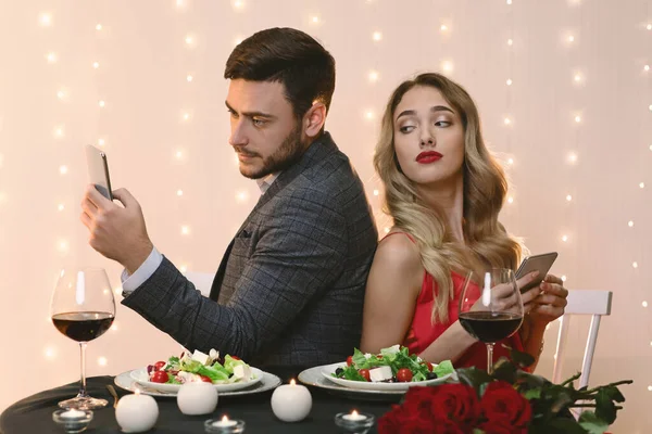 Donna curiosa che sbircia nello smartphone dei fidanzati durante la cena romantica nel ristorante — Foto Stock