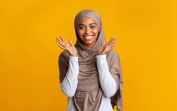 Pleased black muslim girl in hijab raise hands in happy excitement — Stok Foto