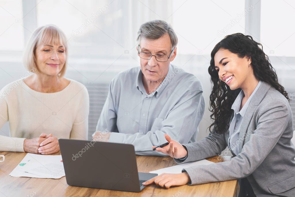 Elderly couple consulting with financial advisor at home