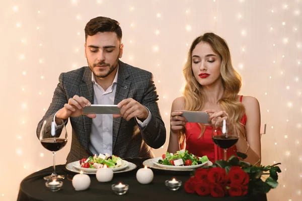 Restoranda romantik bir akşam yemeği yerken fotoğraf çeken çift. — Stok fotoğraf