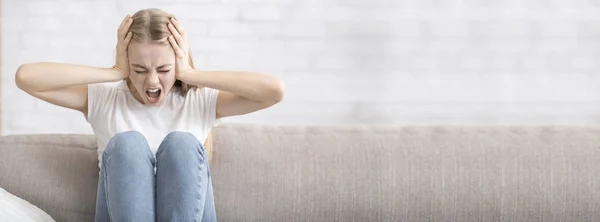 Chica agotada cubriendo oídos y gritando, interior del hogar — Foto de Stock