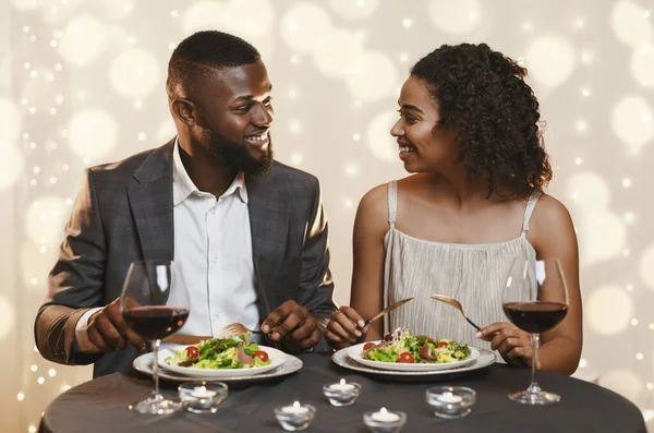 African man and woman talking while having dinner in restaurant — 스톡 사진