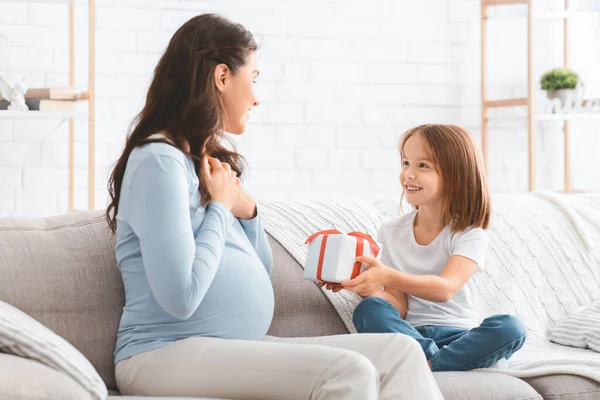Mosolygó óvodás lány üdvözli terhes anyját otthon — Stock Fotó