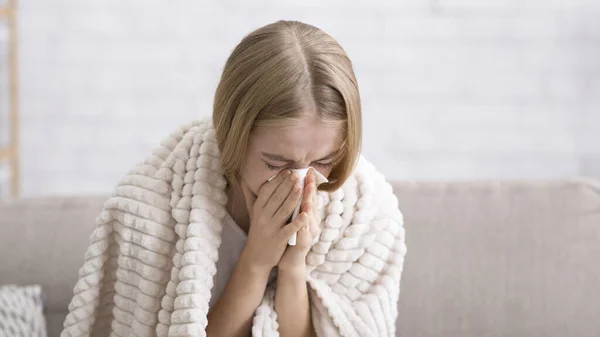 Nahaufnahme eines kranken Mädchens, das sich die Nase pustet — Stockfoto