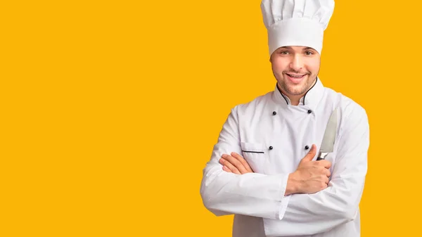 Kok Guy Holding Keuken mes staande over gele achtergrond, Panorama — Stockfoto