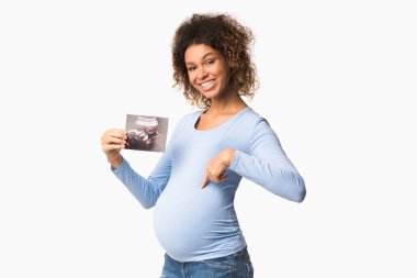 Happy afro pregnant woman with ultrasound scan