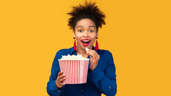 Millennial afro woman with popcorn watching movie — Stock fotografie