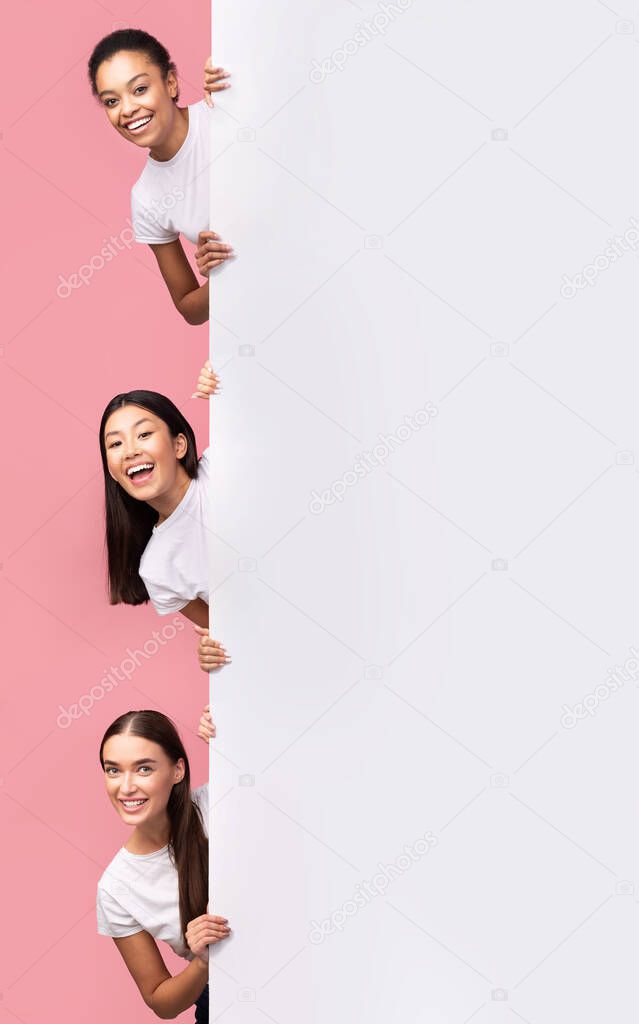 Three Girls Peeking Out Of Blank Board Posing, Pink Background