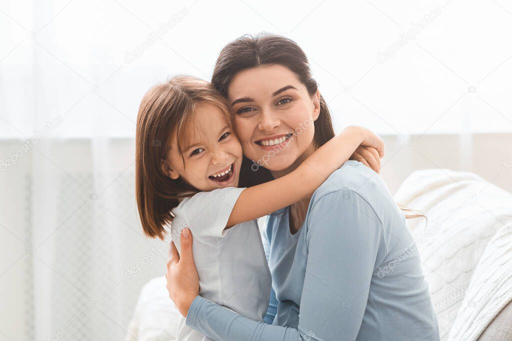 Happy family portrait of embracing mother and little daughter