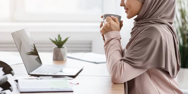 Ontspannen moslim vrouwelijke manager die koffie drinkt op de werkplek — Stockfoto