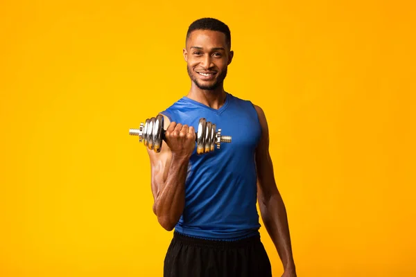 Zwarte bodybuilder pompt biceps met halters — Stockfoto