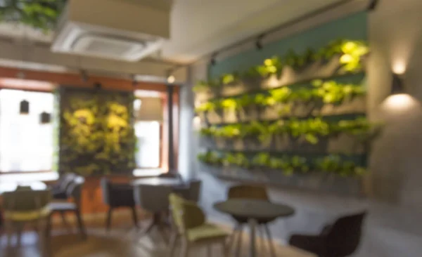 Cafetería borrosa con decoración de plantas verdes en la pared — Foto de Stock