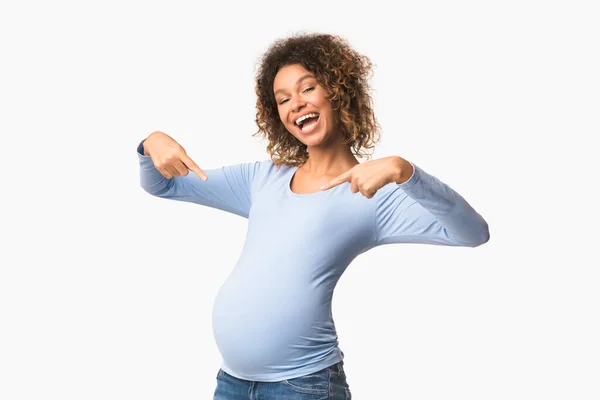 Wanita hamil emosional tersenyum dan menunjuk jari di perut — Stok Foto