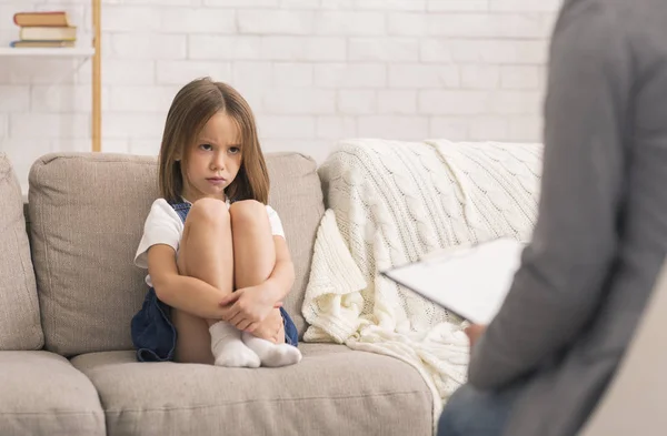 Preoccupato bambina seduta da sola alla sessione di terapia con psicologo dei bambini — Foto Stock