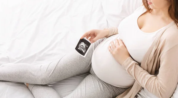 Hamile bir kadın karnını sonografiyle okşuyor. — Stok fotoğraf