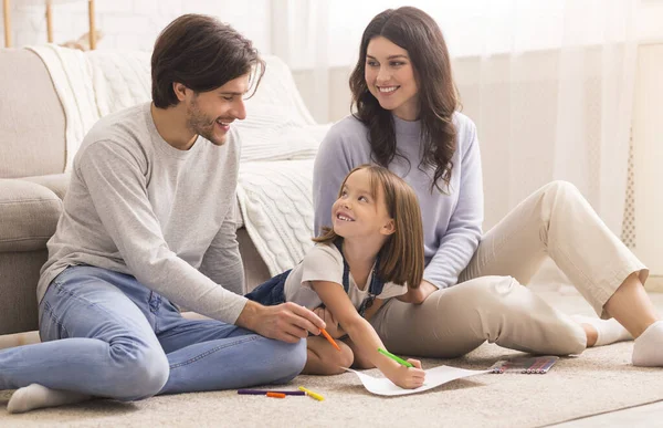 Parents aimants dessin avec petite fille sur le sol dans le salon — Photo