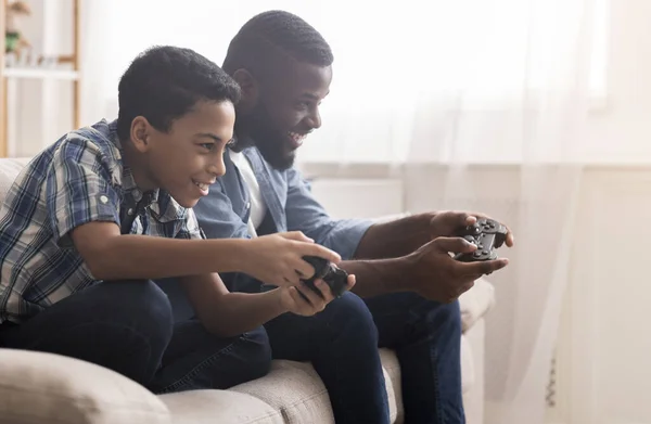 Afro pai e filho jogando videogames com joysticks — Fotografia de Stock