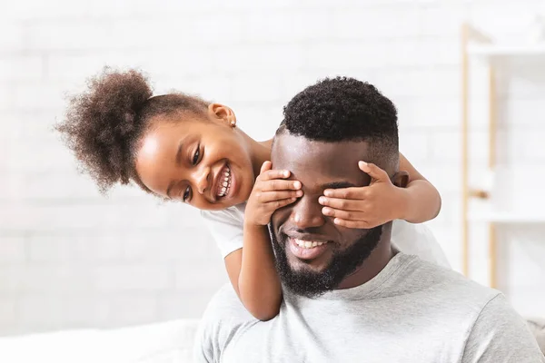 Şirin küçük siyah kız babasının gözlerini kapatıyor. — Stok fotoğraf