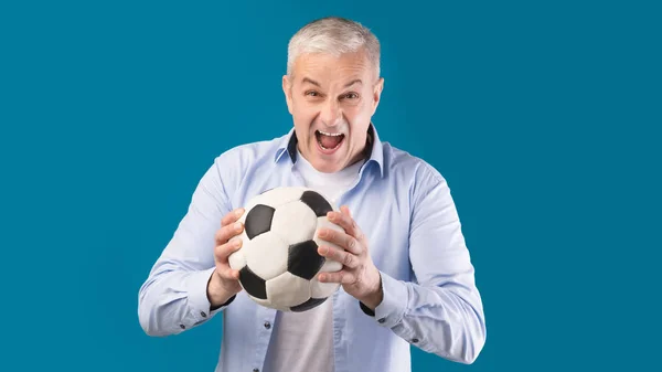 Man poseren met voetbal op blauwe studio achtergrond — Stockfoto