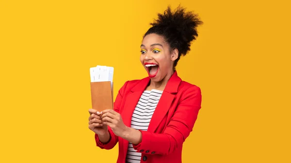 Mulher afro animado segurando bilhetes e passaporte no estúdio — Fotografia de Stock