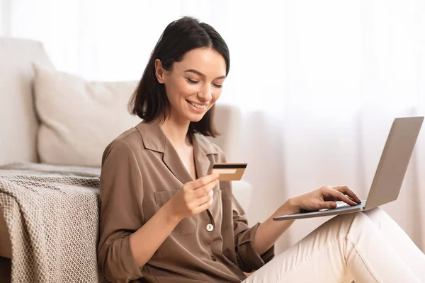 Mujer joven haciendo compras sentada en su piso — Foto de Stock