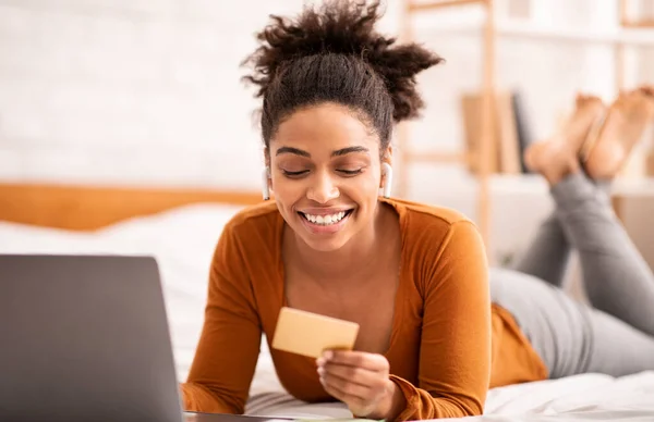 Young Afro Lady Shopping Online Lying In Bed In Bedroom — Stock Photo, Image