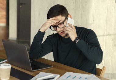 Ofis müdürünün evde otururken cep telefonuyla konuşması yorucu.
