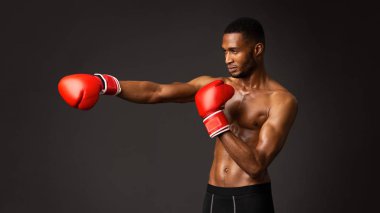 Boks eldivenli yakışıklı afro boksör yumruk atıyor.