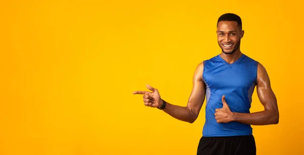 Happy afro sporter wijzen op vrije ruimte voor promo — Stockfoto