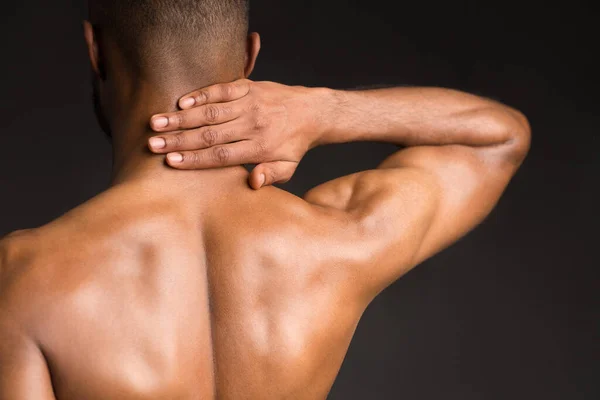 Hombre negro sin camisa que sufre de dolor en el cuello —  Fotos de Stock