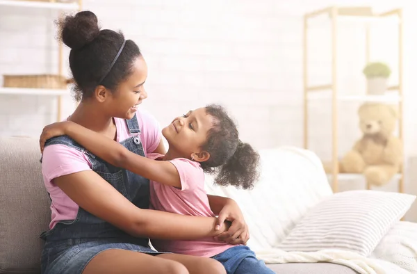 Alegres hermanas africanas abrazándose en casa, espacio vacío — Foto de Stock