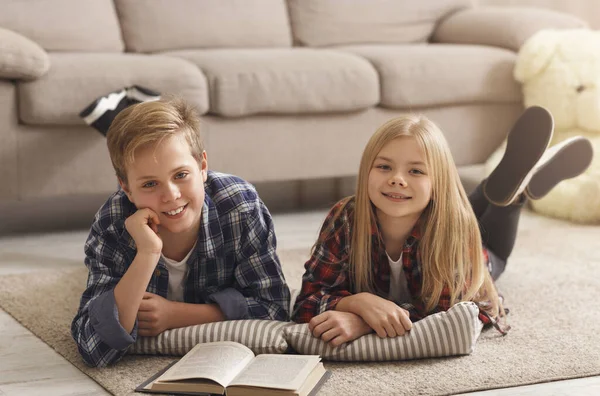 Boy And Girl Reading Book Together Lying On Floor Indoor — Stock Photo, Image