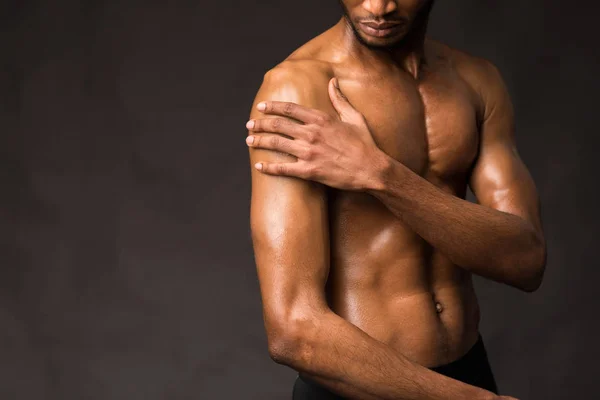 Unrecognizable black man showing body on dark gray wall — Stock Photo, Image
