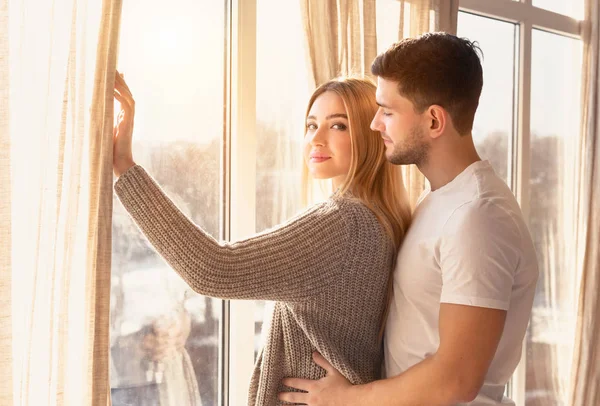 一对浪漫快乐的年轻夫妇拥抱在窗前 — 图库照片