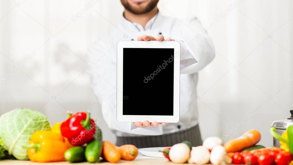 Unrecognizable Male Chef Showing Blank Tablet Screen Standing In Kitchen