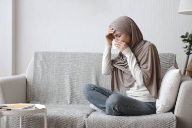 Evde sıcaklıktan ve akan burundan muzdarip hasta bir Müslüman kız