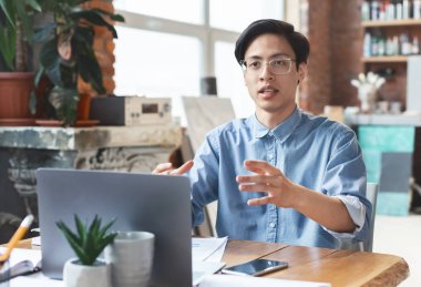 Hevesli Asyalı adam yaratıcı fikirlerini meslektaşlarıyla paylaşıyor.