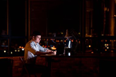 Genç İşadamı Laptop 'ta fazla mesai yapıyor Modern Ofiste oturuyor