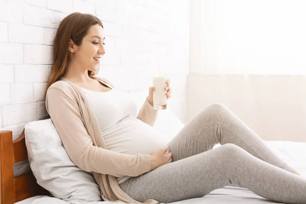 Joven embarazada sosteniendo vaso de leche fresca — Foto de Stock