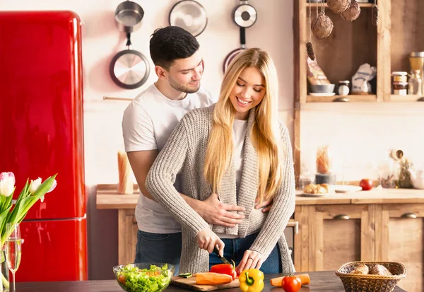 Pareja joven recién casada abrazando y cocinando juntos —  Fotos de Stock