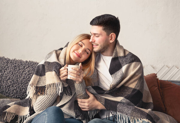 Happy couple in love with plaid and cup of hot chocolate relaxing