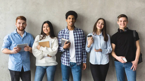 Grupo multiétnico de estudiantes universitarios contra la pared universitaria — Foto de Stock