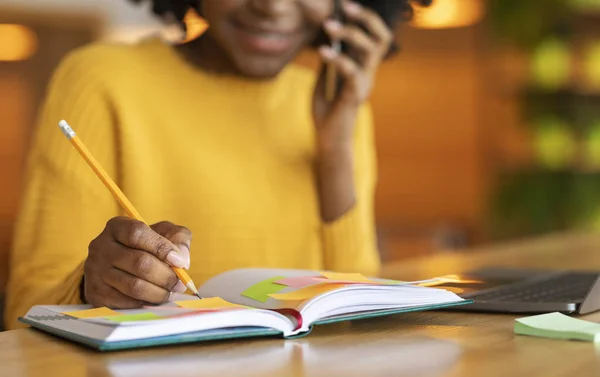 Abgeschnitten von Afro-Mädchen telefoniert, Notizen macht — Stockfoto