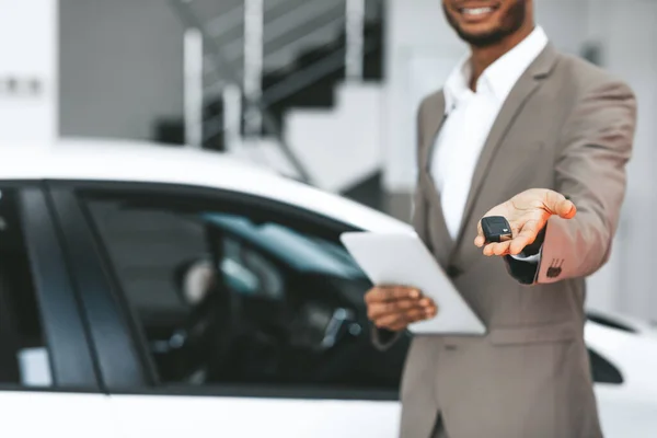 Unrecognizable Seller Offering Car Key Standing In Dealership Center, Cropped — 스톡 사진