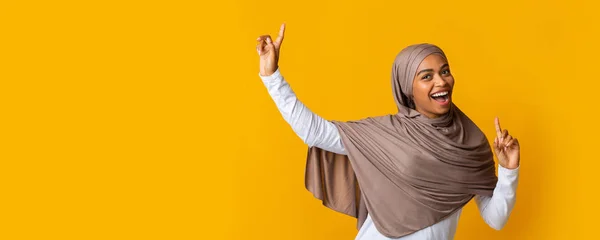 Wesoły afro muzułmanin dziewczyna w hidżab zabawy na żółtym tle — Zdjęcie stockowe