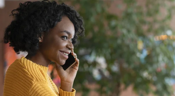 Портрет улыбающейся афро-девушки, разговаривающей по телефону — стоковое фото