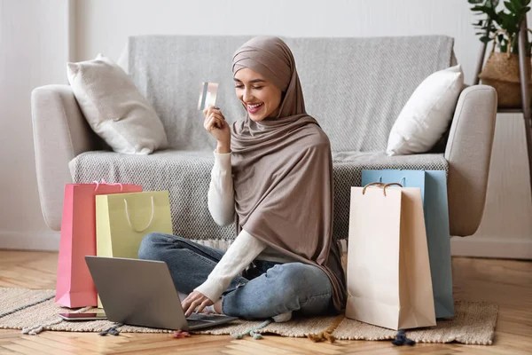 Çevrimiçi alışveriş için kredi kartı ve laptop kullanan modern Arap kız — Stok fotoğraf